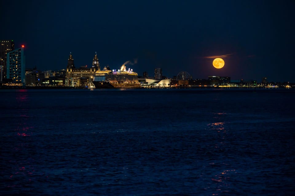 A Strawberry super moon rises to the right of the Liverpool skyline.